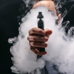 Person hält einen Vaporizer in der Hand, umgeben von dichter Dampfwolke – Tipps zum Vaporizer kaufen.