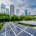 Vor einer Stadt sind mehrere Solaranlagen aufgebaut