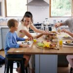 Glückliche Familie genießt gemeinsames Frühstück in einer gemütlichen Ferienwohnung